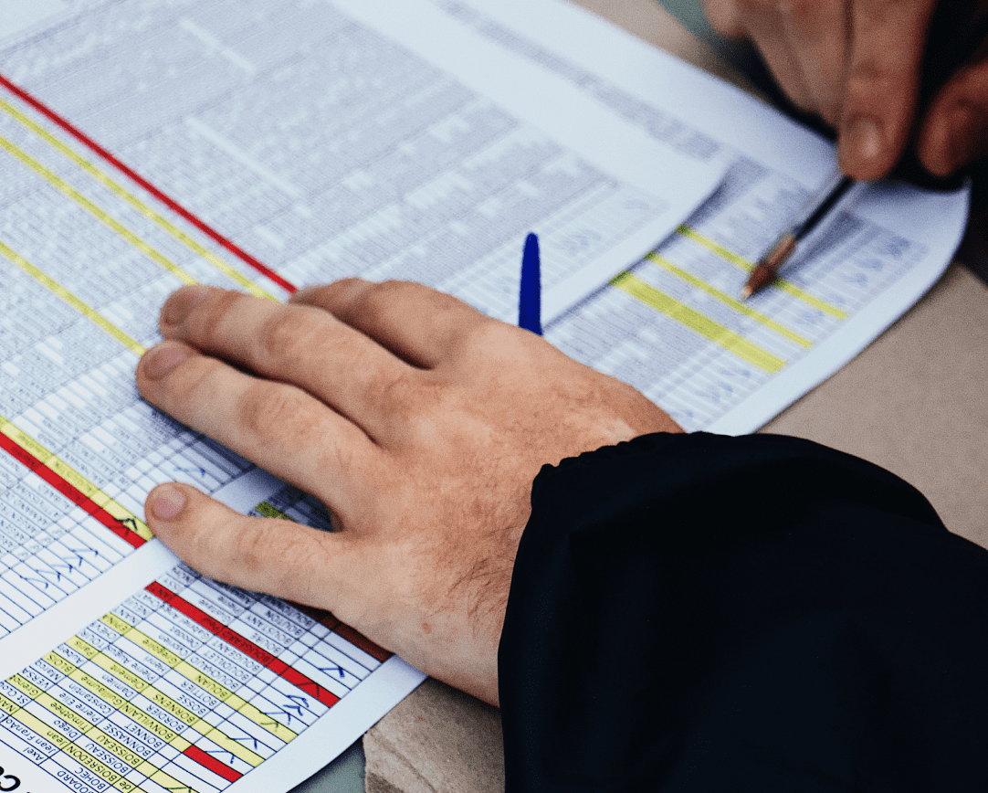 Close-up of two hands using pens to point at document