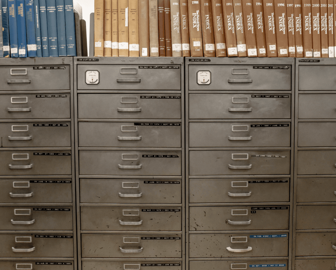 Four towers of filing cabinets with reference books on top