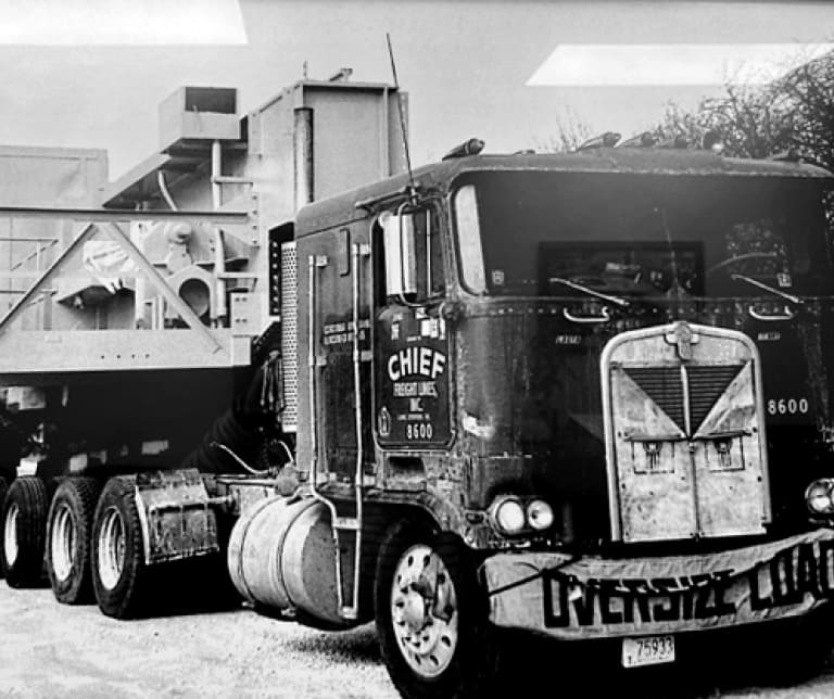 Black-and-white photo of Chief Freight Lines truck with "Oversize Load" banner hanging over bumper