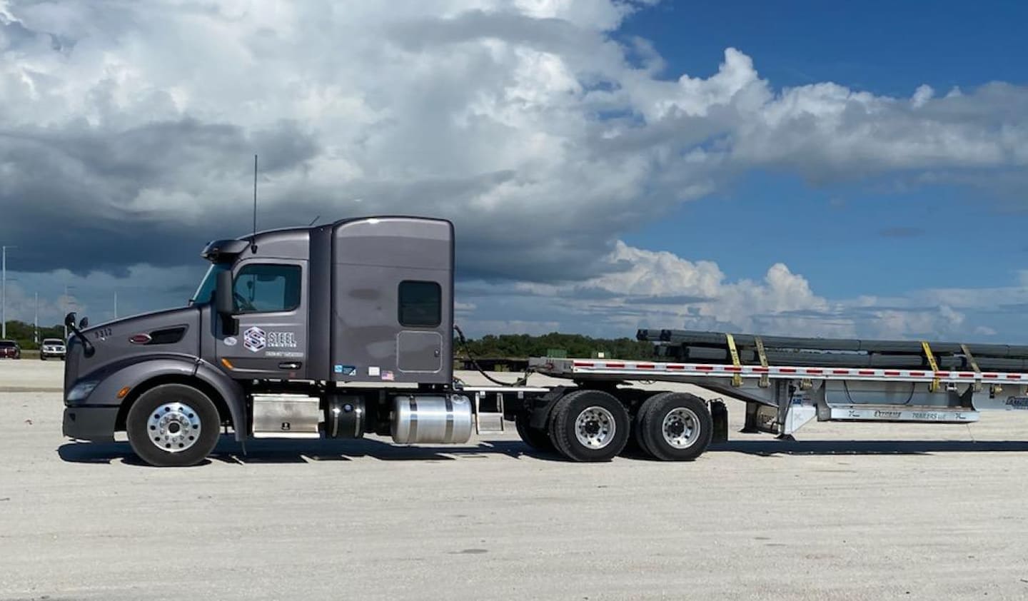 Modern flatbed truck with Steel Logistics logo on the door