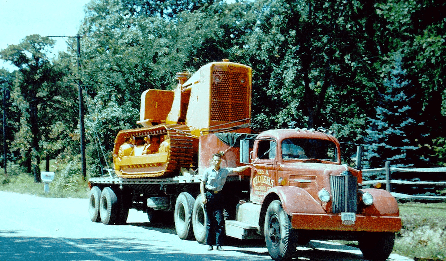 A man standing next to a red truck